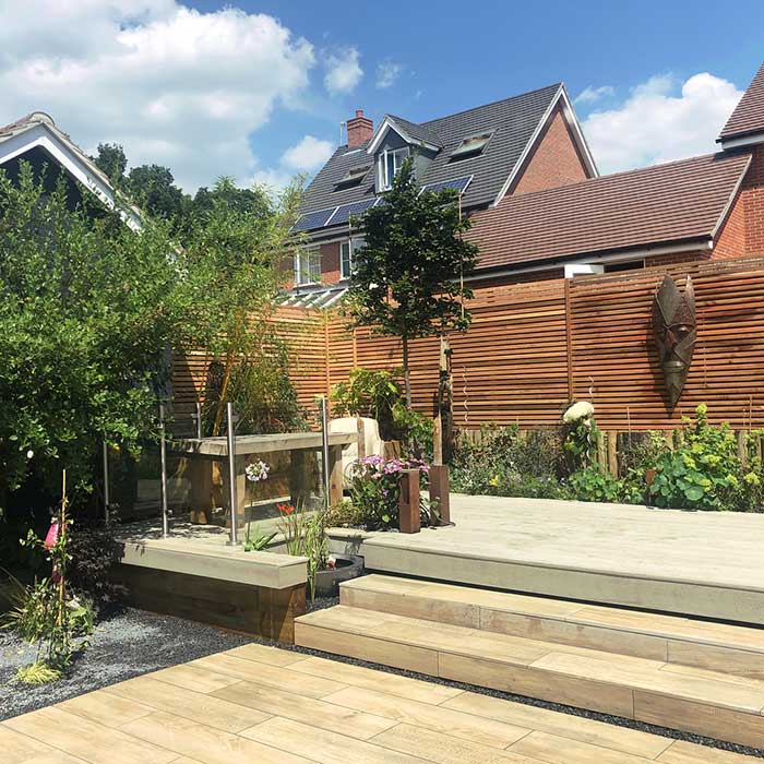 Smoked oak Millboard and wood effect paving, cedar trellis & glass balustrade - Kent